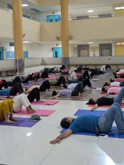 Participants practicing a reclining asana during a session at a college. We ensure our sessions are suitable for all fitness levels, making Yoga accessible to everyone.