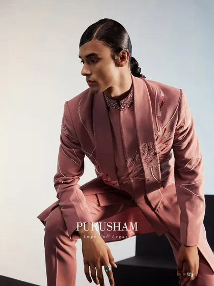 I love exploring color to tell a story. This dusty rose ensemble, with its subtle tonal embroidery and modern silhouette, captures a softer side of masculine elegance. It is a contemporary choice for the discerning groom.