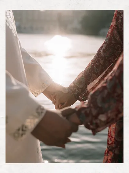 A close-up of hands held together against the sparkling waters of Udaipur. Sometimes the smallest details tell the biggest story of love and commitment.