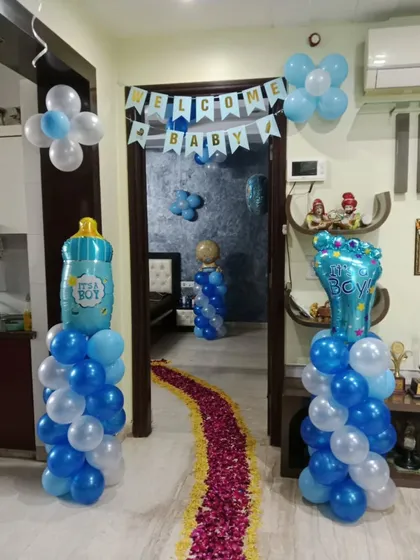 Balloon pillars with "It's a Boy" foil toppers and a rose petal walkway create an inviting entrance for the new baby.