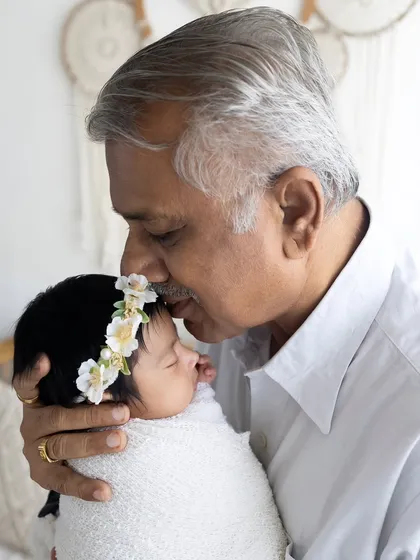 There's nothing quite like the bond between a grandparent and a newborn. This tender moment shows a grandfather's gentle kiss, a priceless memory captured during a newborn family photoshoot.