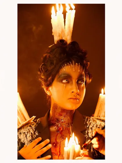A profile shot from the dark fantasy candle shoot, highlighting the dramatic lighting and the gory special effects makeup on the neck.