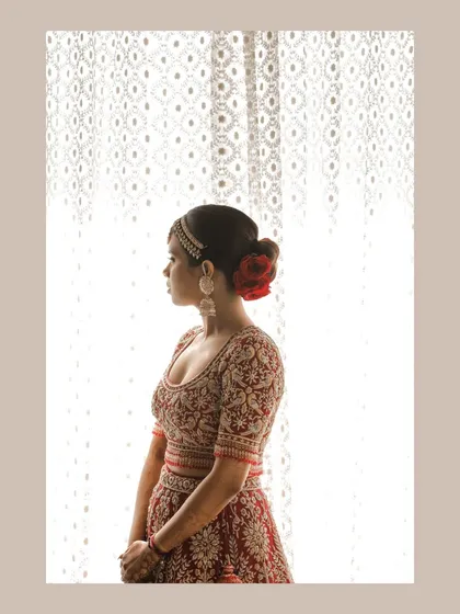 A silhouette of the bride against an intricately designed window in Jaipur. This artistic shot highlights both the bride's beauty and the stunning heritage venue.