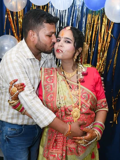 A sweet kiss from the husband during an indoor maternity celebration. We capture the love and support of family during this special time.