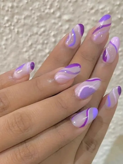 Riding the wave with these trendy purple swirl nails. Using different shades of lilac and violet, I created a groovy, abstract pattern over a sheer base for a fun and modern look.