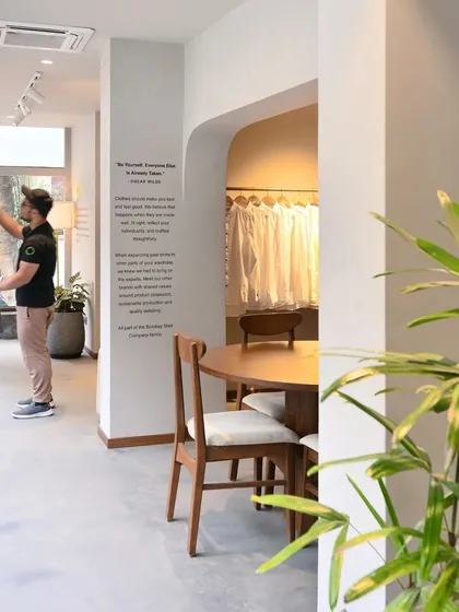 A customer browses shirts at the Bombay Shirt Company, highlighting the interactive and personalized nature of the retail experience we designed.