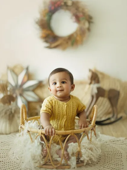 This sweet baby boy in a wicker basket is part of a boho-themed 8-month milestone session. I use natural props and soft lighting to create a warm and inviting atmosphere.