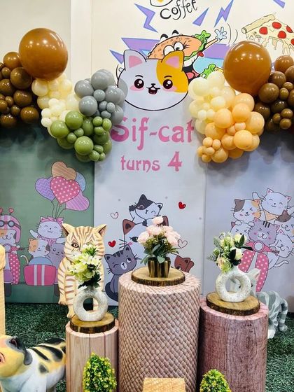 A well-lit shot of the cat party backdrop, showing the cute cartoon illustrations and the colorful balloon arrangement.