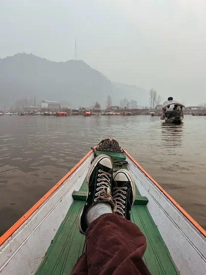 My view from a shikara on Dal Lake. Just my feet, the boat, and the misty mountains in the distance. A perfect moment of peace and reflection.