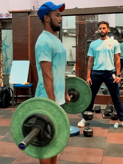 An athlete performs a deadlift while I watch his form intently. The deadlift is a crucial full-body exercise for developing the posterior chain, essential for running, jumping, and throwing power.