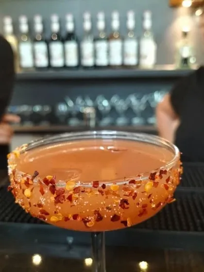 Learn to create cocktails with a kick. This is a close-up of a spicy cocktail with a chili-flake rim, a creation from one of our practical classes in Bangalore that teaches flavor balance and presentation.