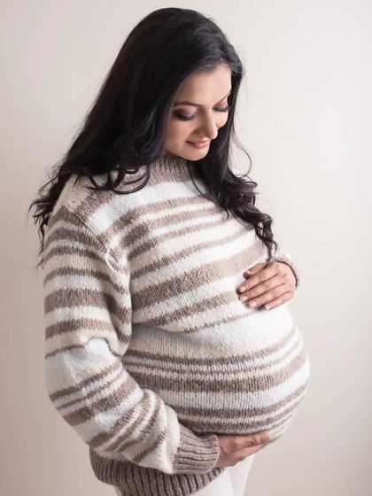 Cozy and chic in a striped sweater that accentuates her perfect bump. This simple and sweet solo portrait captures the warmth and comfort of awaiting your little one.