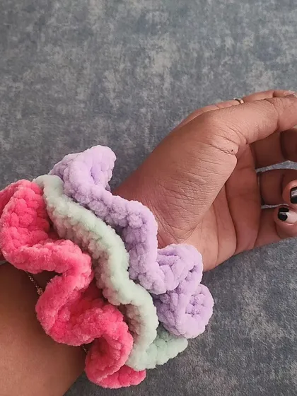 My super soft and fluffy velvet scrunchies are not just for your hair, they also look adorable on your wrist. Here you can see a stack of three in bright pink, mint green, and pastel purple. They are designed to be gentle on your hair and add a fun touch of color.