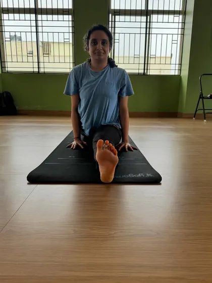 A front view of a student working towards Hanumanasana. This perspective shows the alignment of the hips and the engagement of the front leg, crucial for a safe and deep stretch.