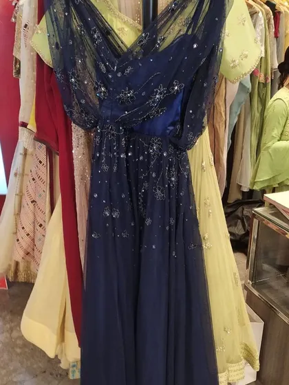 A celestial-themed navy blue gown with a draped tulle overlay sprinkled with silver sequins that look like stars. This whimsical and romantic dress is perfect for a cocktail night or a sangeet.