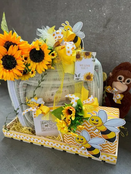 A sweet and sunny bee-themed baby hamper. This gift basket is filled with essentials and decorated with sunflowers and cute bee cutouts, bringing a ray of sunshine to the new parents.