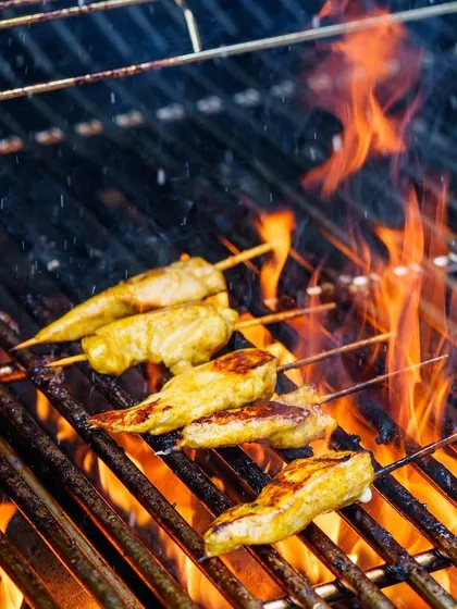 Our chefs expertly prepare chicken satay skewers on the grill. This popular dish is a highlight of our themed brunches, loved for its tender texture and rich, savory glaze.