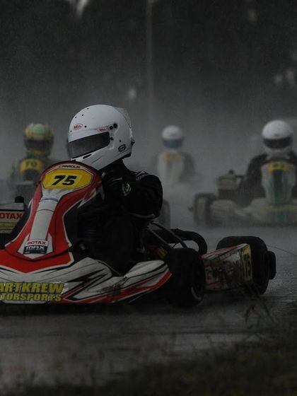 A group of karts navigating a wet track in the RMC Round 4.
