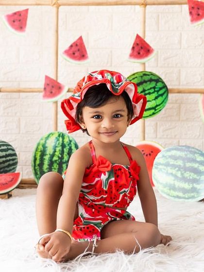 A sweet portrait from the watermelon-themed session. The combination of the cute outfit and the colorful setup makes for an adorable birthday photo.