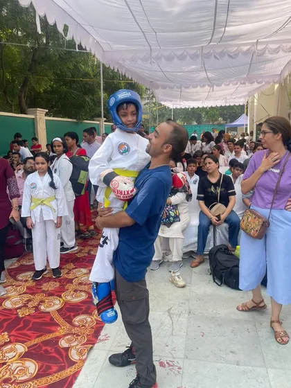 Lifting a young student after his event. Supporting my athletes, especially the youngest ones, is a key part of my role as a coach.