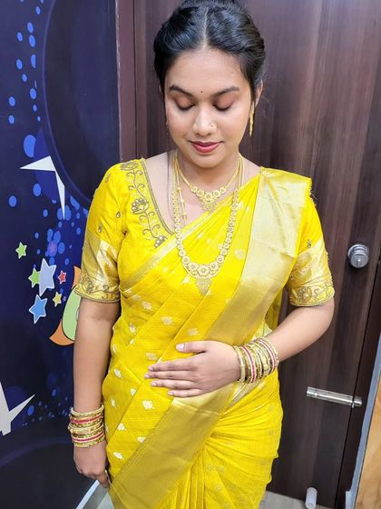 A simple yet elegant gold saree draping for a pooja ceremony. The pleats are kept neat and the pallu is arranged for ease of movement during the rituals.