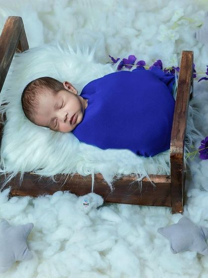Tucked into a tiny wooden bed surrounded by fluffy clouds and stars. This dreamy setup shows how I use props to create a magical scene for your sleeping newborn.