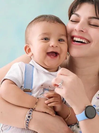 The purest joy captured in a mother-and-son portrait. The light blue background adds a soft pop of color while keeping the overall feel bright, happy, and focused on their infectious laughter.