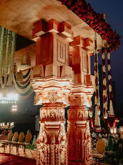 The powerful pillars of the temple mandap, showcasing the detailed carving work that gives the structure its authentic and majestic feel.