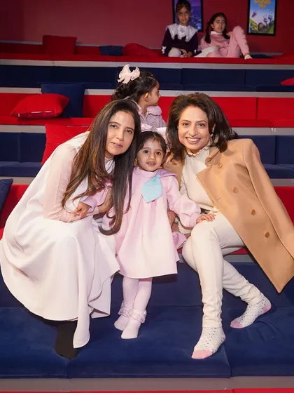 Two mothers enjoying a moment with the birthday girl in our private kids' movie theatre during a Barbie-themed party. Our venue offers diverse spaces for guests to enjoy.