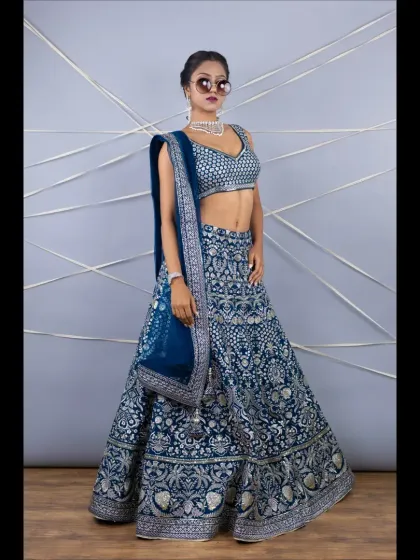 A full-length shot of the navy blue lehenga with heavy silver embroidery. The rich color and intricate work make it a perfect choice for a reception or sangeet.