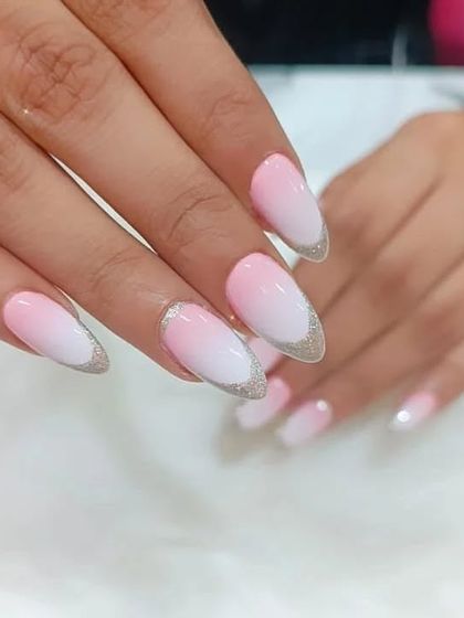 A soft pink-to-white ombre on almond nails, with a sparkling silver glitter tip for an elegant finish.