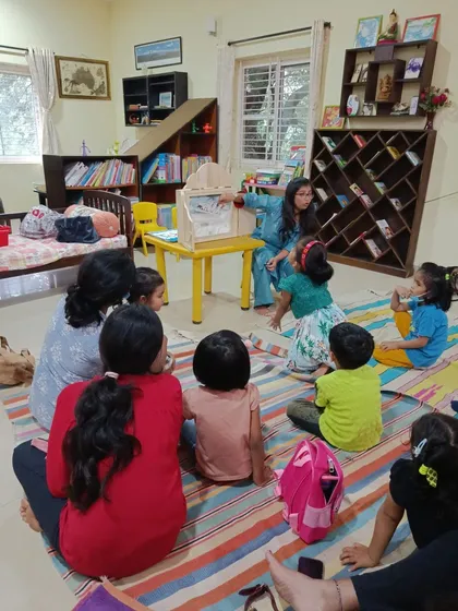 The children interact with the Kamishibai, pointing at the pictures and asking questions.