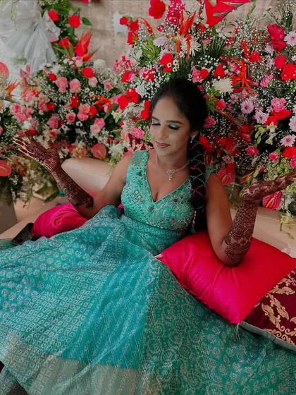 The vibrant colors of the decor and outfit are beautifully complemented by the rich, dark patterns of the mehndi art.