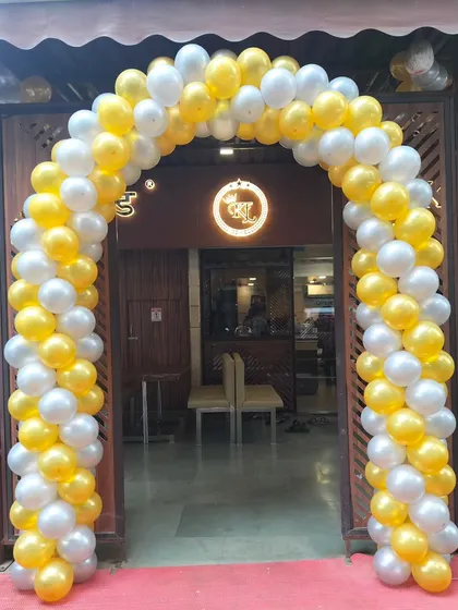 A bright yellow and white balloon arch creating a welcoming entrance for a local shop. This classic two-color spiral design is a popular choice for making a big impact.