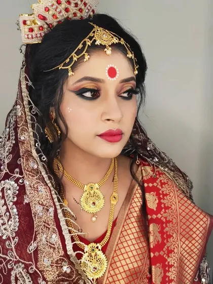 I have experience with many regional styles, including traditional Bengali bridal makeup. This look features the iconic large bindi, mukut, and dramatic eye makeup that are signatures of a Bengali bride.
