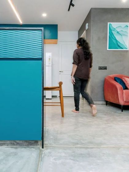 A view from the kitchen pass-through into the living area, showcasing the dynamic interplay of teal, blush, and grey tones.