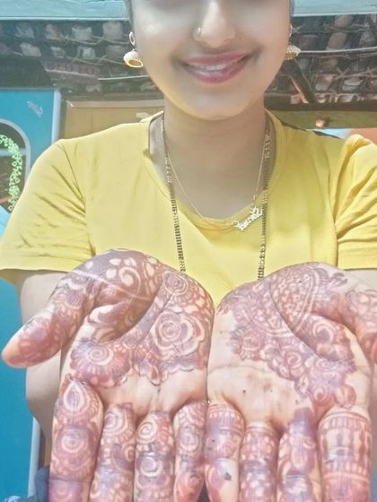 A client showing her palms after the henna paste has been removed, revealing a lovely orange stain that will darken over time.