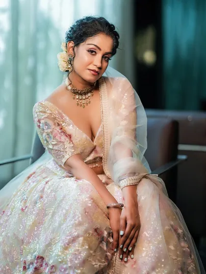 This image demonstrates our use of soft, natural light to create a dreamy and elegant atmosphere. The model, seated in a delicate floral lehenga, conveys a sense of quiet grace, highlighting the fine details of the embroidery and fabric.