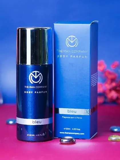 A clean, professional shot of 'The Man Company' body perfume, using contrasting colors and simple props. This style is effective for creating striking images for men's grooming brands.