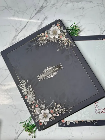 This design is for the modern couple seeking elegance and sophistication. The deep charcoal box is adorned with delicate, embossed floral artwork, creating a beautiful contrast. It's a chic and contemporary take on the classic wedding invitation.