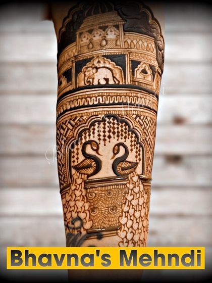 A close up of a breathtakingly detailed bridal arm. This design features graceful swans and elephants within ornate architectural frames, showcasing the highest level of intricacy.