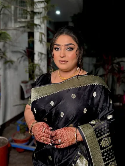 Another shot of this stunning black saree look. The focus is on the dramatic eye makeup, which adds a touch of glamour perfect for an evening reception or party.