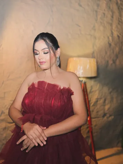 A glamorous cocktail look in a beautiful burgundy gown. The makeup features a soft smokey eye and a defined contour to complement the dramatic dress.