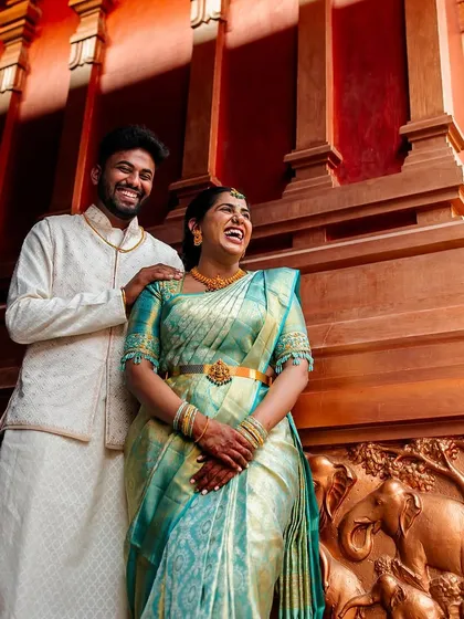 We live for authentic laughter. This moment from a vibrant engagement shoot shows the couple's genuine happiness, set against a stunning traditional backdrop. Our goal is to capture the feelings you'll want to remember forever.