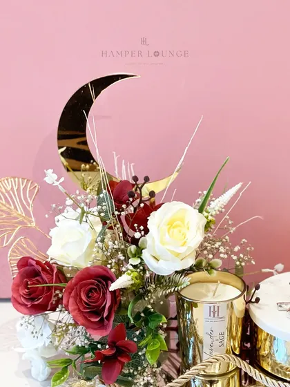 A detailed look at the floral arrangement in the crescent moon Eid hamper. The mix of red and white roses with the golden accents creates a rich and celebratory mood.