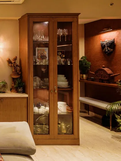 A duplex entryway with a terracotta texture wall adorned with a Durga mask, blending modern lines with traditional art.