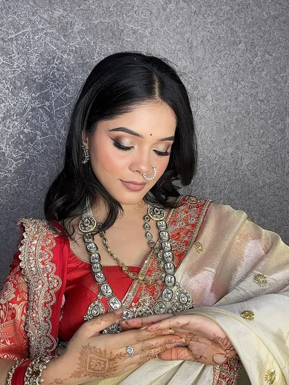A graceful pose showing the complete look with the elegant red and cream saree.