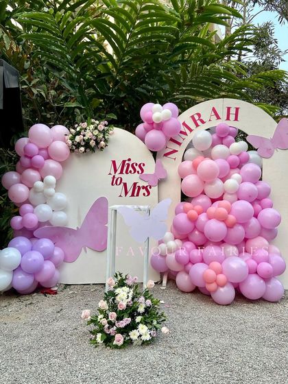 A sweet 'Miss to Mrs' butterfly-themed bridal shower. We used arches decorated with pink, purple, and white balloon garlands and delicate butterfly cutouts to create a dreamy and feminine photo backdrop.