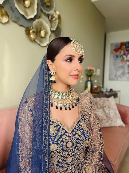 A side profile showcasing the sleek bridal updo and the flawless contouring along the jawline. The makeup is designed to be picture-perfect from every angle.