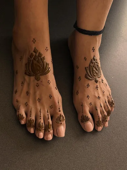 A simple and elegant lotus design for the feet. The central lotus is complemented by smaller buds on the toes, creating a clean and beautiful look.